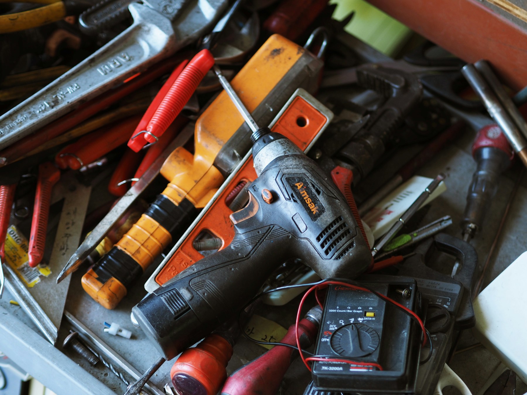 Power drill and hand tools on a busy workshop bench